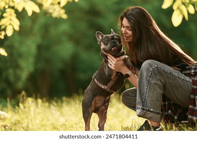 Sitting on the grass, embracing an animal. Young pretty woman is with her dog in the park. - Powered by Shutterstock