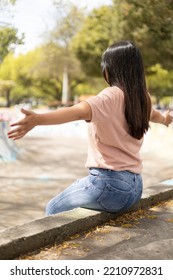 Sitting On Her Back Opening Her Arms A Woman With Long Straight Hair, Lifestyle In A Park With Nature, Landscape