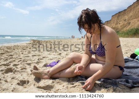 sitting on the shore of a woman,young woman sitting on the beach bowed her head