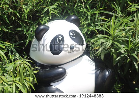 A sitting panda statue in a garden