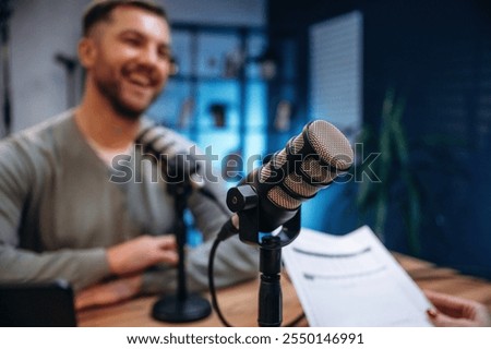 Sitting and smiling. Man with microphone in the studio, conception of podcast.