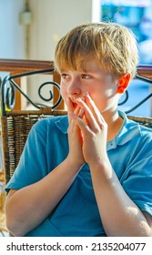 Sitting Young Blonde Boy  With Brown Eyes Looks Astonished