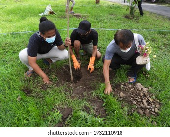Situbondo, Indonesia - march 03 2021: environmental groups and the village government are planting trees together on the side of the village road