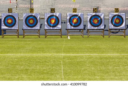 Six archery target rings during an archery competition. Green grass.