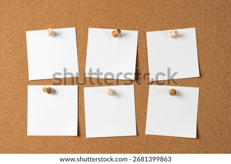Six blank white notes pinned to a cork bulletin board with wooden push pins, creating space for reminders, messages, or ideas in an organized layout.