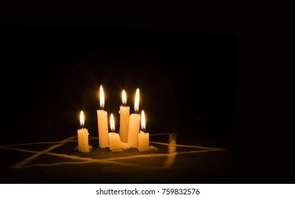 Six burning candles and the Star of David against a black background, text Yom Hashoah, We will never forget, the Jewish Holocaust and Heroism Remembrance Day