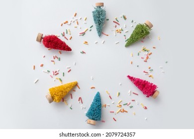 Six Colorful Mini Bottle Brush Christmas Tree Flat Lay With Sprinkles