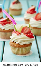 Six Decorated Pina Colada Cupcakes On The Wooden Table