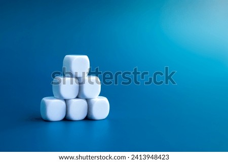 Six empty white cube dice blocks building as pyramid shape isolated on blue background with copy space. White minimalist brick stack for icons or marketing process symbol. Business growth concepts.