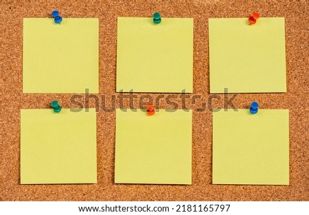 Six empty yellow sticky notes on a cork board with drawing pins, copy past