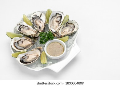 Six Fresh Oysters With Lime Wedges And Citrus Vinaigrette Sauce