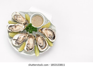 Six Fresh Oysters With Lime Wedges And Citrus Vinaigrette Sauce