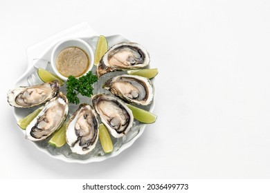 Six Fresh Oysters With Lime Wedges And Citrus Vinaigrette Sauce