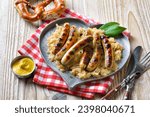 Six fried Nuremberg sausages with sauerkraut on a heart-shaped pewter plate, served with mustard and a Bavarian pretzel