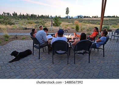 Six Friends Around A Fire Pit Enjoy Afternoon View Of Landscape Around Sisters, Oregon On A Perfect Summer Afternoon.