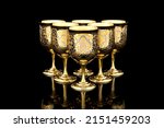 Six Golden Antique Vintage Brass Shot Glass Gilded on black background. metal Wine Cup goblet with Carving Engraving pattern.