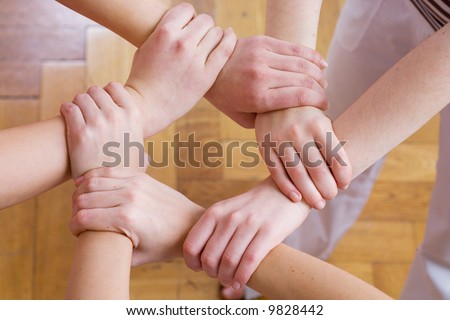 six hands linked to form a circle