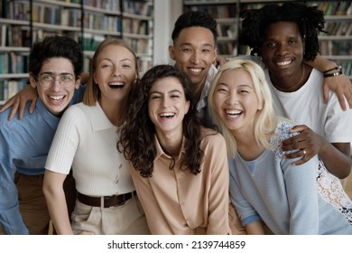 Six happy multi ethnic students laughing pose look at camera standing hugging in college library. Excellent study in university, education in higher institution, multiracial friendship, unity concept