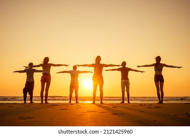six health people in stand hatha position with hand up raced and breath full chest in Goa India beach at sunset - Powered by Shutterstock