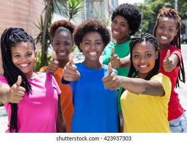Six laughing african american girlfriends showing thumbs up