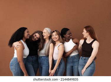 Six Laughing Women Of Different Body Types And Ethnicities In Studio. Group Portrait Of Smiling Females Standing Together Against Brown Background.