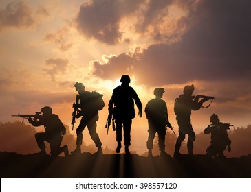 Six military silhouettes on sunset sky background