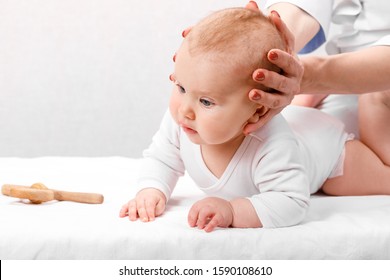 Six month baby girl receiving osteopathic or chiropractic treatment in pediatric clinic. Manual therapist manipulates chils's head and neck - Powered by Shutterstock