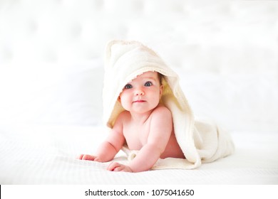 Sechs Monate Baby mit Handtuch nach dem Bad. Konzept der Kinderbetreuung