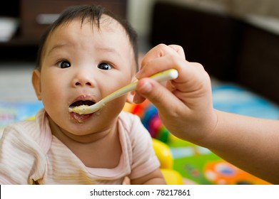 Six Month Old South East Asian Chinese Baby Girl Being Spoon Fed