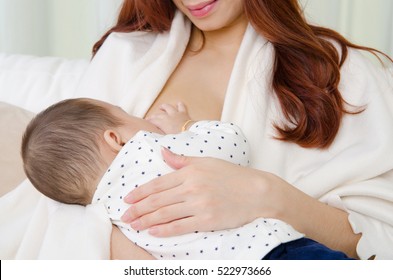 Six months old asian baby drinking breastmilk