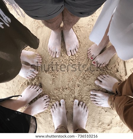 Six pairs of feet on on sand