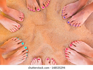 Six Pairs Of Woman Feet On The Sand