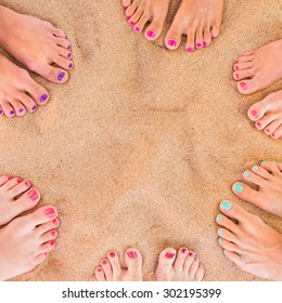 Six Pairs Of Woman Feet On The Sand
