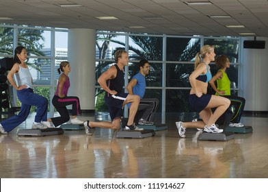 Six People Exercising On Step In Aerobics Class