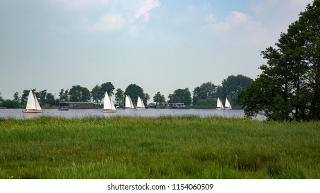 Six sailing boats on Dutch lake; Friesland, Netherlands - Shutterstock ID 1154060509