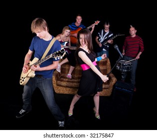 Six Teens In A High School Rock Band Practicing On A Stage.