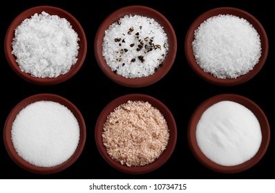 Six Terracotta Plates With Different Salt - Flakes Sea Salt, Coarse Sea Salt With Crashed Black Pepper, Coarse Sea Salt, Fine Sea Salt, Smoked Flaky Sea Salt, Table Salt, Isolated On Black