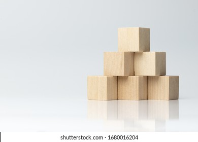 Sechs hölzerne Blöcke, die auf Pyramidenform angeordnet sind, einzeln auf weißem Hintergrund