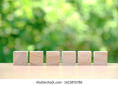 Six Wooden Blocks On Table With Green Bokeh Background