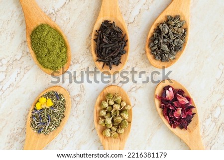 Six wooden spoons with various types of tea. Green tea, black tea, matcha, chamomile, hibiscus and herbal tea for healthy lifestyle, medicinal purposes. Natural skin care herbal medicine.