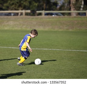 Six Year Old Boy Playing Soccer On A Saturday Morning