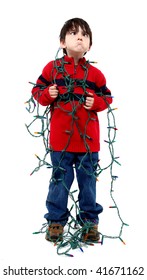 Six year old boy with tangled Christmas tree lights.