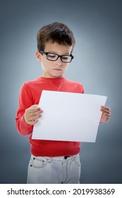 Six Year Old Caucasian Boy In Studio With Blank A4 Sheet Of Paper In Hands. 