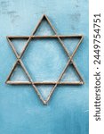 A six-sided Jewish star or Magen David made from metal strips and mounted to a blue, metal door. 