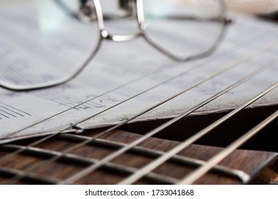 six-string guitar strings on a background of glasses on a soft pastel background close-up