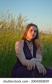 Sixteen Year Old Girl Sitting In Tall Grass In Rural Germany On A Warm Spring Night.