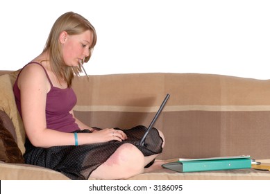 Sixteen Year Old Teenage Girl, Birthmark On Knee Doing Homework On Laptop, In Sofa At Home.  Education Concept.