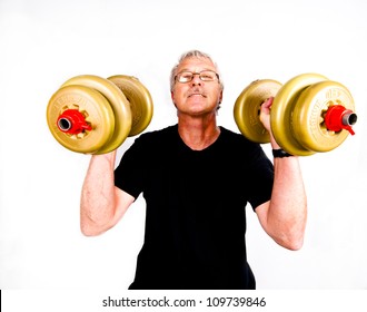 Sixty Four Year Old Senior Man, Grey Haired And Wearing A Black T-shirt, Lifting Weights And Smiling. Isolated On White.