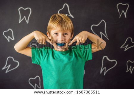 Six-year old boy shows myofunctional trainer. Helps equalize the growing teeth and correct bite, develop mouth breathing habit. Corrects the position of the tongue
