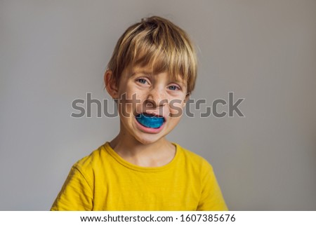 Six-year old boy shows myofunctional trainer. Helps equalize the growing teeth and correct bite, develop mouth breathing habit. Corrects the position of the tongue